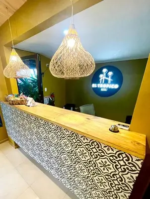 a bar with two lights and a sign on the wall at Hotel y Cabinas del Trópico in Guápiles