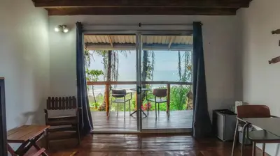a room with a door open to a patio with a table and chairs at Hotel Buenos Aires in Santa Teresa Beach