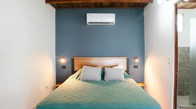 a bedroom with blue walls and a bed with white pillows at Hotel Buenos Aires in Santa Teresa Beach