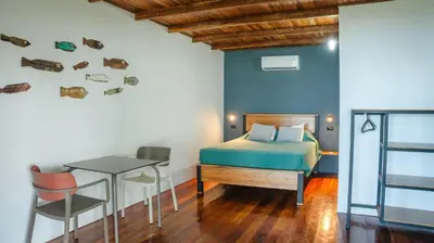 a bedroom with a bed and a desk and a table at Hotel Buenos Aires in Santa Teresa Beach