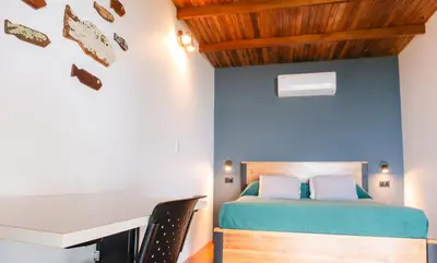 a bedroom with a bed and a desk at Hotel Buenos Aires in Santa Teresa Beach