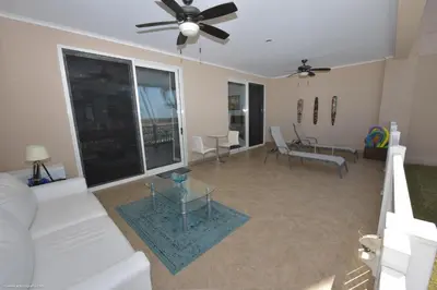 a living room with a white couch and a ceiling fan at The Palms Jaco in Jacó