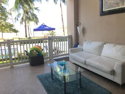 a living room with a white couch and a glass table at The Palms Jaco in Jacó