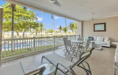 a balcony with tables and chairs and a view of the ocean at The Palms Jaco in Jacó