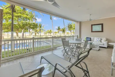 a living room with a balcony with tables and chairs at The Palms Jaco in Jacó