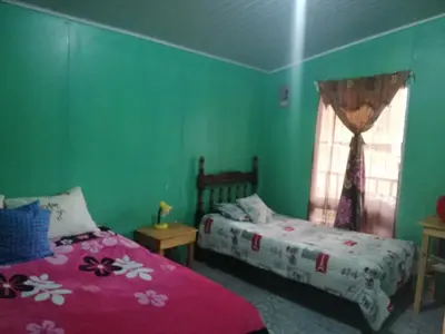 a bedroom with two beds and a window at Cabañas San Gerardo in San Gerardo de Dota