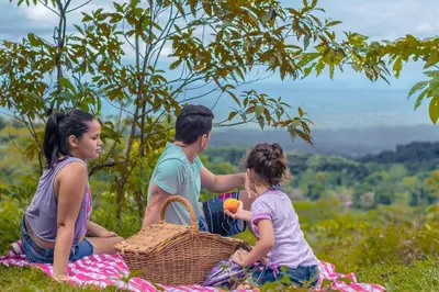 a group of people sitting on a picnic blanket at La Tigra Rainforest Lodge in Fortuna