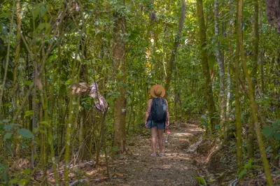 a woman walking down a trail in the jungle at La Tigra Rainforest Lodge in Fortuna
