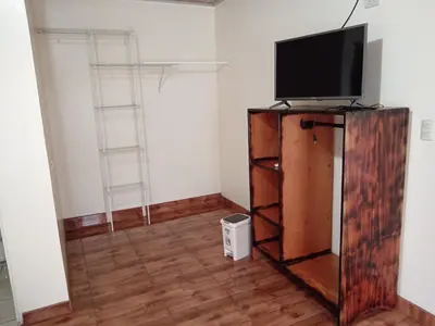 a living room with a television on a wooden entertainment center at Posada Rural Río Celeste in Rio Celeste