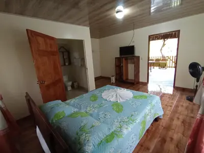 a bedroom with a bed with a blue comforter at Posada Rural Río Celeste in Rio Celeste