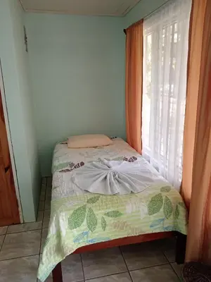 a small bed in a room with a window at Posada Rural Río Celeste in Rio Celeste