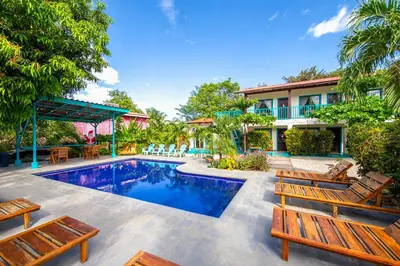 a house with a swimming pool and some chairs at Hotel Diversion Tropical in Brasilito