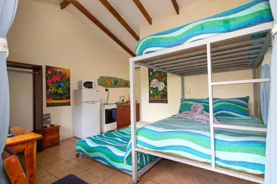 a bedroom with a bunk bed and a kitchen at Hotel Diversion Tropical in Brasilito