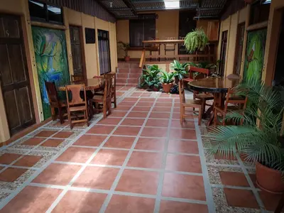 an empty patio with tables and chairs and a table and chairsktop at Greemount Hotel in Monteverde Costa Rica