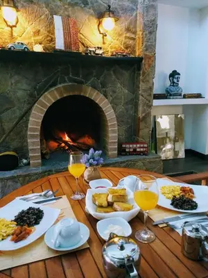 a table with plates of food and a fireplace at Vistas del Conde in Heredia