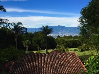 a view of a roof of a house with palm trees at Vistas del Conde in Heredia