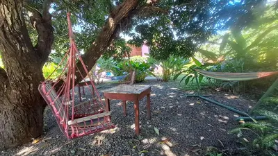 a hammock and a table and a hammock under a tree at Dolce Uvita in Bahia