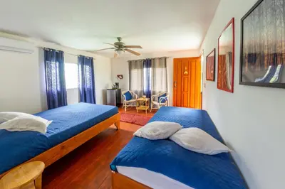 two beds in a room with blue sheets at Dolce Uvita in Bahia