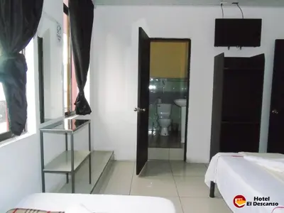 a room with a toilet and a door to a bathroom at Hotel El Descanso in San José