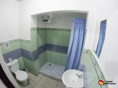 a bathroom with a shower and a toilet and a sink at Hotel El Descanso in San José