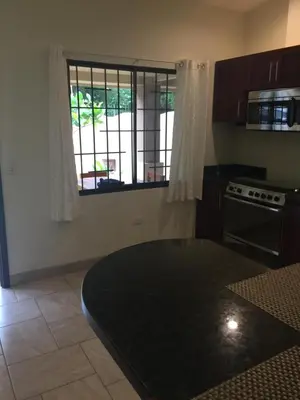 a kitchen with a black table and a window at Guest House in Playa Flamingo