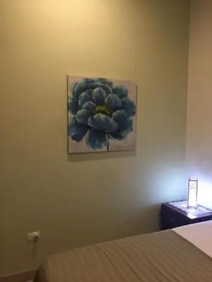 a bedroom with a painting of a flower on the wall at Guest House in Playa Flamingo