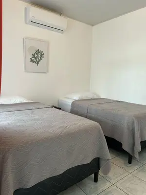 a room with two beds and a picture on the wall at Hotel Alicia in Fortuna
