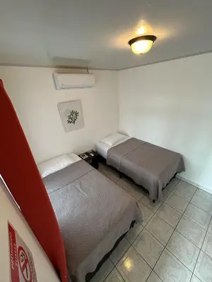 a room with two beds and a light on the wall at Hotel Alicia in Fortuna