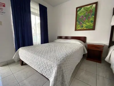 a bedroom with a bed and a picture on the wall at Hotel Alicia in Fortuna