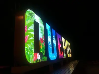 a lit up sign on a building in the dark at Hotel Malinche in Quepos