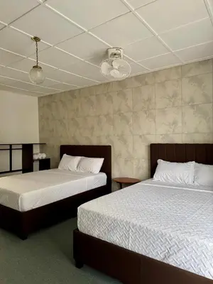 two beds in a room with two beds sidx sidx sidx at Hotel Malinche in Quepos