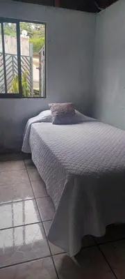 a bed in a room with a large window at Hostel Paco House in Monteverde Costa Rica