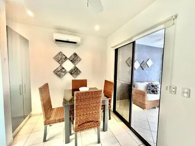 a dining room with a table and chairs at Tropical Gardens Suites and Apartments in Coco
