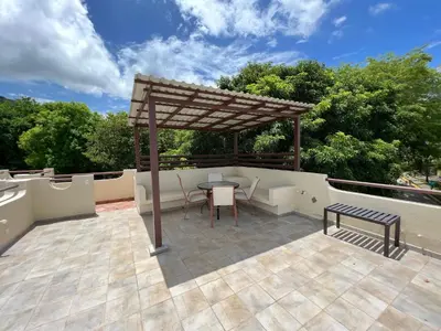 a patio with a gazebo and a table and a bench at Tropical Gardens Suites and Apartments in Coco