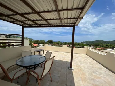 a patio with a table and chairs on a balcony at Tropical Gardens Suites and Apartments in Coco