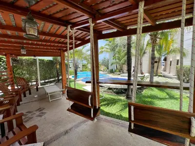 a pavilion with benches and a view of a pool at Tropical Gardens Suites and Apartments in Coco