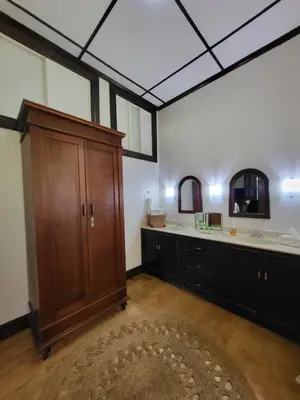 a bathroom with two sinks and a wooden cabinet at Casa del Cafe-Familiar in Heredia