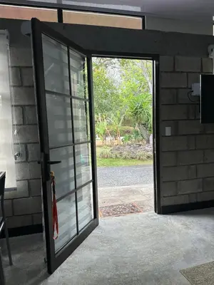 an open glass door to a building with a patio at Casa del Cafe-Familiar in Heredia