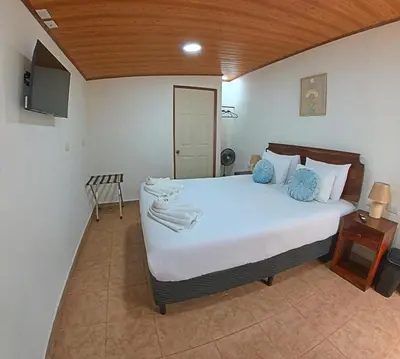 a bedroom with a large bed with blue pillows at Casa Jungle Monteverde B&B in Monteverde Costa Rica
