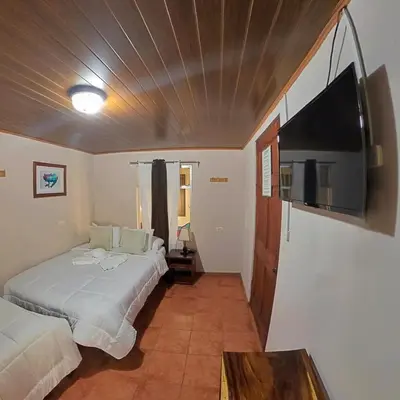 a bedroom with two beds and a flat screen tv at Casa Jungle Monteverde B&B in Monteverde Costa Rica