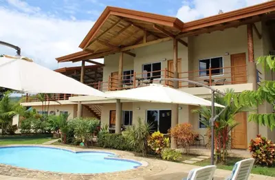 a villa with a swimming pool and umbrellas at Vista Villas in Ojochal
