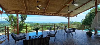 a patio with tables and chairs on a balcony at Vista Villas in Ojochal