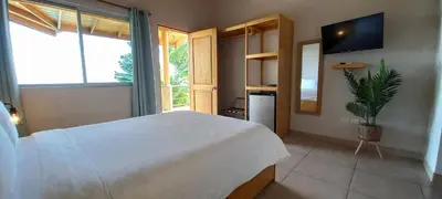 a bedroom with a large white bed and a plant at Vista Villas in Ojochal