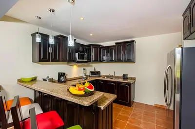 a kitchen with wooden cabinets and a counter top at Beautiful and comfortable Two Bedrooms Beach Condo in Coco