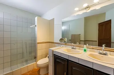 a bathroom with two sinks and a toilet and a mirror at Beautiful and comfortable Two Bedrooms Beach Condo in Coco