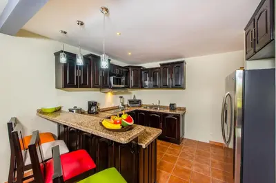 a kitchen with wooden cabinets and a refrigerator at Beautiful and comfortable Two Bedrooms Beach Condo in Coco