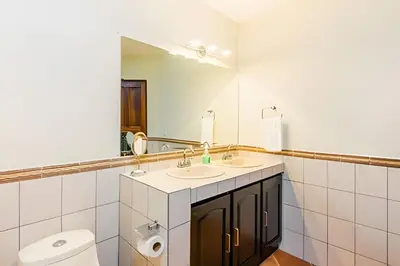 a bathroom with two sinks and a toilet and a mirror at Beautiful and comfortable Two Bedrooms Beach Condo in Coco