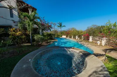 a swimming pool in a yard next to a house at Beautiful and comfortable Two Bedrooms Beach Condo in Coco