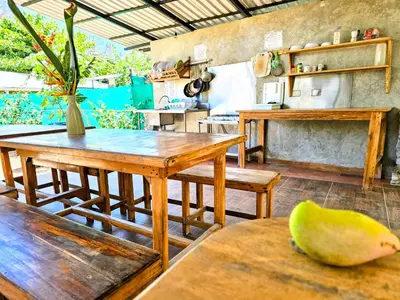 a kitchen with wooden tables and a banana on the table at Don Jon's Surf and Yoga Lodge in Santa Teresa Beach