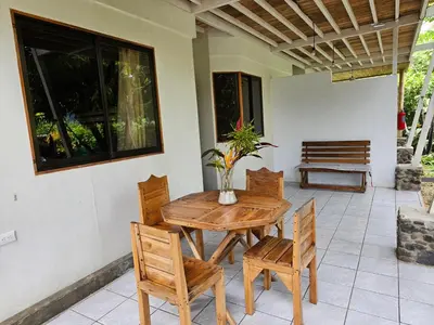 a wooden table and chairs on a patio at Don Jon's Surf and Yoga Lodge in Santa Teresa Beach